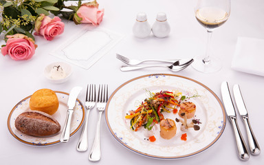 Table layout. Giving of a dish. Combs with mushrooms of a shitaka and fresh vegetable salad. Are served with roll of black and white loaf with butter. 