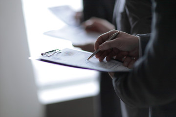 close up. businessman with clipboard checking statistics