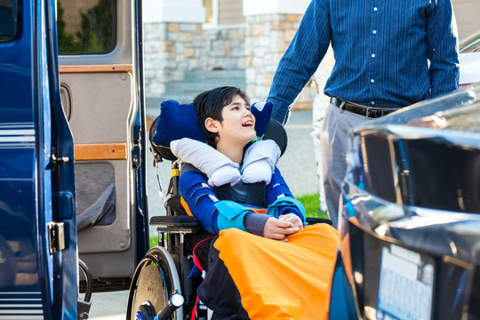 Special needs boy in wheelchair on vehicle handicap lift