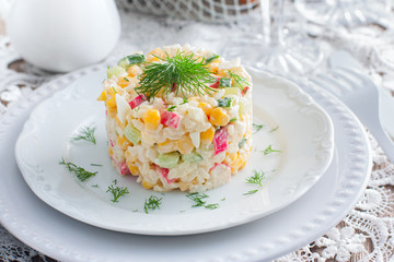 Crab salad with corn, laid out on a white plate for portion serving in a festive table setting, horizontal