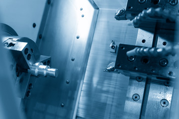 The CNC lathe or turning machine cutting  the thread  at the metal shaft.Hi-technology manufacturing process.