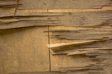 Old dirty broken light yellow plywood on a wooden surface. wooden texture.