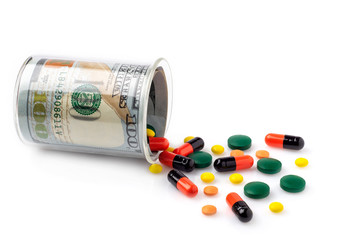 Colorful pills spilled from a bottle made of money, on white background. The Concept of Drug Purchase.
