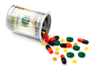 Colorful pills spilled from a bottle made of money, on white background. The Concept of Drug Purchase. The concept of rising medicines.