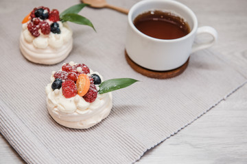 Pavlova meringue cake with cream and small fruits