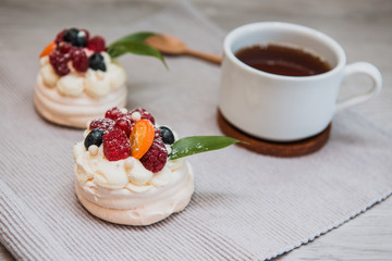 Pavlova meringue cake with cream and small fruits