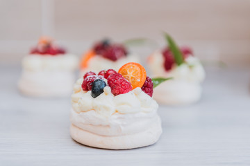 Pavlova meringue cake with cream and small fruits