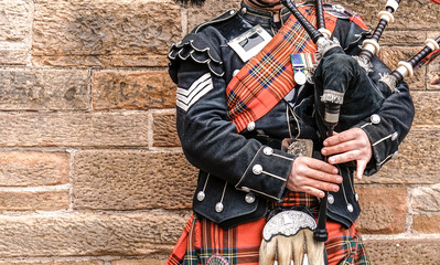 EDINBURGH, SCOTLAND, 24 March 2018 , Scottish bagpiper dressed in traditional red and black tartan...