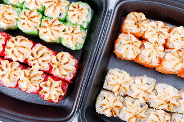 Sushi in plastic packaging. Baked sushi with flying fish roe. Sushi in a plastic box close up.