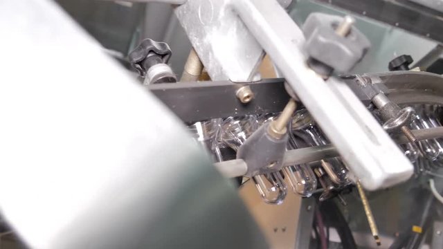Plastic preform bottles move through the machine for blowing