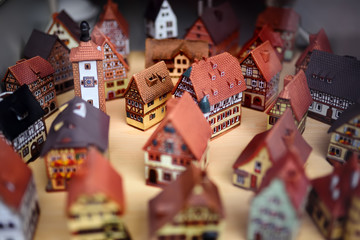 Naklejka premium Decorative ceramic houses candle holders on the shelf of Christmas marketplace.
