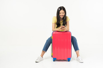 Beautiful young woman smiling and pulling pink color luggage isolated on white background.Woman going to summer vacation.Travel trip funny...