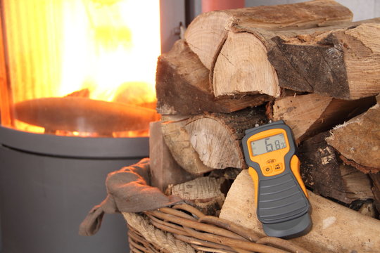 Feuchtigkeitsmesser und Holz vor einem Kamin 1