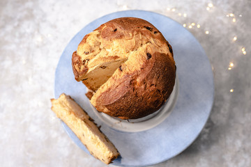 panettone: traditional Italian dessert for Christmas with raisins and candied orange, sliced. Bokeh lights. Horizontal photo 
