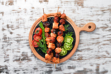Chicken shish kebab with cherry tomatoes on a white wooden background. Meat. Top view. Free copy space.