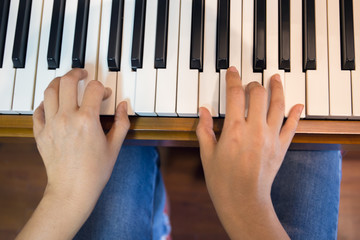 Close up of happy woman's hand playing the piano in the morning.