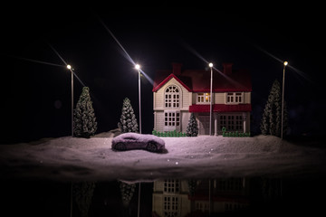 Little decorative houses, beautiful festive still life, cute small houses at night, Night city real bokeh background, happy winter holidays. Selective focus