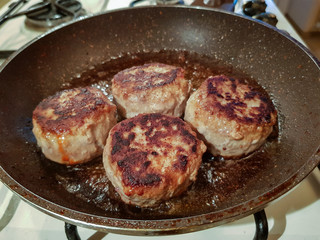 Juicy appetizing cutlets from a mixed different types of meat in a dripping pan in oil
