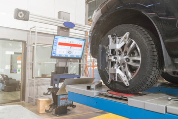 A Car on the Car Steering Wheel Balancer and Calibrate with laser reflector attach on each tire to...