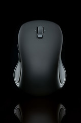 Black computer mouse on a black background with reflection