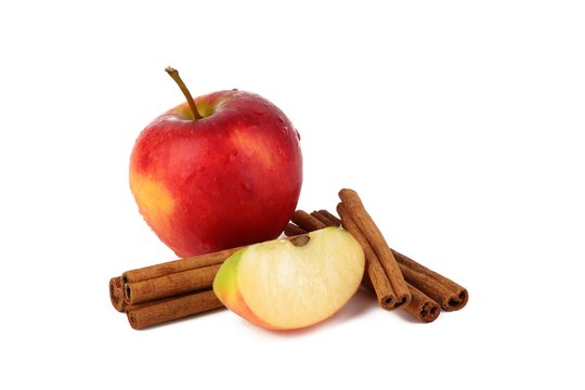 
Red ripe apple and aromatic cinnamon sticks on white background