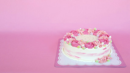Flowers cream birthday cake over pink background