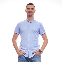 Casually handsome. Confident young handsome man in jeans shirt keeping arms crossed and smiling while standing against white background