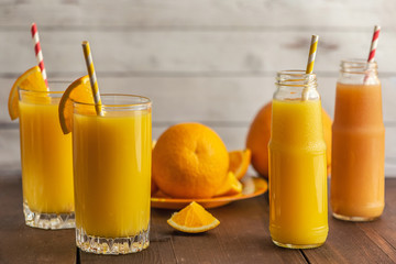 Glasses of Fresh Orange Juice on light wooden background. Side view