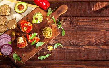 Collection of sandwiches on a cutting board and wooden table