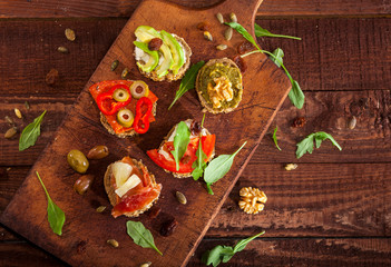 Collection of sandwiches on a cutting board and wooden table