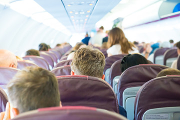 Fototapeta premium Passengers sit inside airplane - people traveling