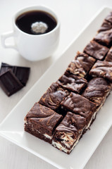 Chocolate brownie with a cup of coffee. High key.
