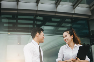 Two business people talking together at office building.