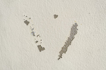 Cream wall with cracked old layers of paint.