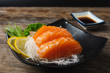 Sashimi, Salmon, Japanese food chopsticks and wasabi on the wood table