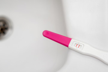 Close up of  pregnancy test showing a positive result on basin in bathroom, Selective focus, Abortion problem, Wellness and healthy concept.