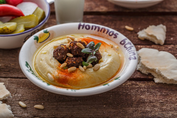Close view of hummus with meat and olive oil