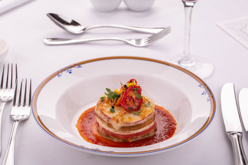 A lasagna with tomatoes and greens