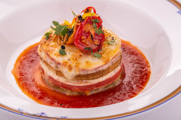 A vegetarian lasagna with tomatoes and greens in tomato sauce