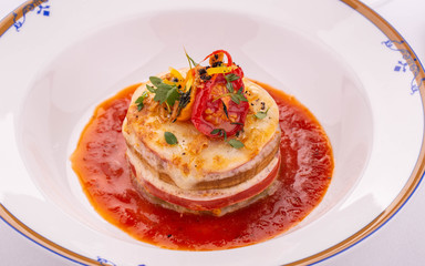 A cheese lasagna with meat under tomato sauce with dried tomatoes