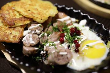 Sausages and potato pancakes in skillet