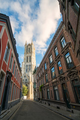 Fototapeta na wymiar Beautiful narrow street of Ghent city, view to the Saint Bavo Cathedral