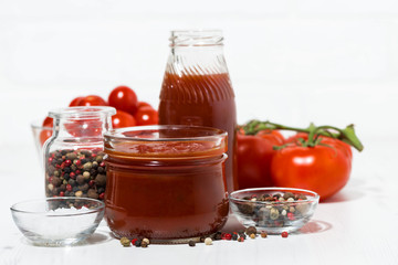 Products made with fresh tomato - sauce, juice and seasonings on white table