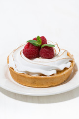 sweet tartlet with meringue and raspberry on white plate, vertical