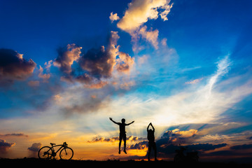 silhouette boys jumping on the rural fields with bicycle and motorbike, sunset background.