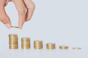 golden coins stack with business hand man put coin on growth up top coin isolated on white gray background and reflection. financial and saving concept. ESG Environmental Social Governance. startup.