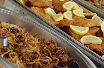 Knusprige panierte Schnitzel mit Zitronenscheiben auf einem Buffet