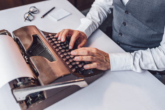 Male hands typing on a retro typewriter