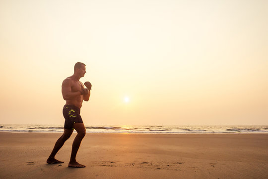 Young Handsome Man Applying Cream Sunscreen Lotion On The Sea Beach.Sexy Male Model Athlete Bodybuilder Posing The Perfect Athletic Body ,epilation And Depilation Shugaring Concept