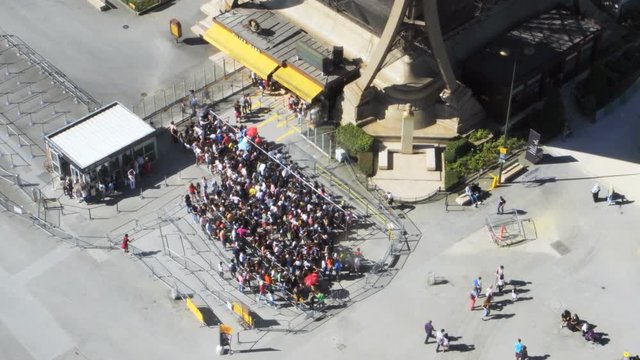 PARIS, FRANCE - CIRCA JUNE 2018: People waiting in line for entrance to the Eiffel Tower, view from the first floor. An anti-terror metal fence and bulletproof glass are being built around the tower.